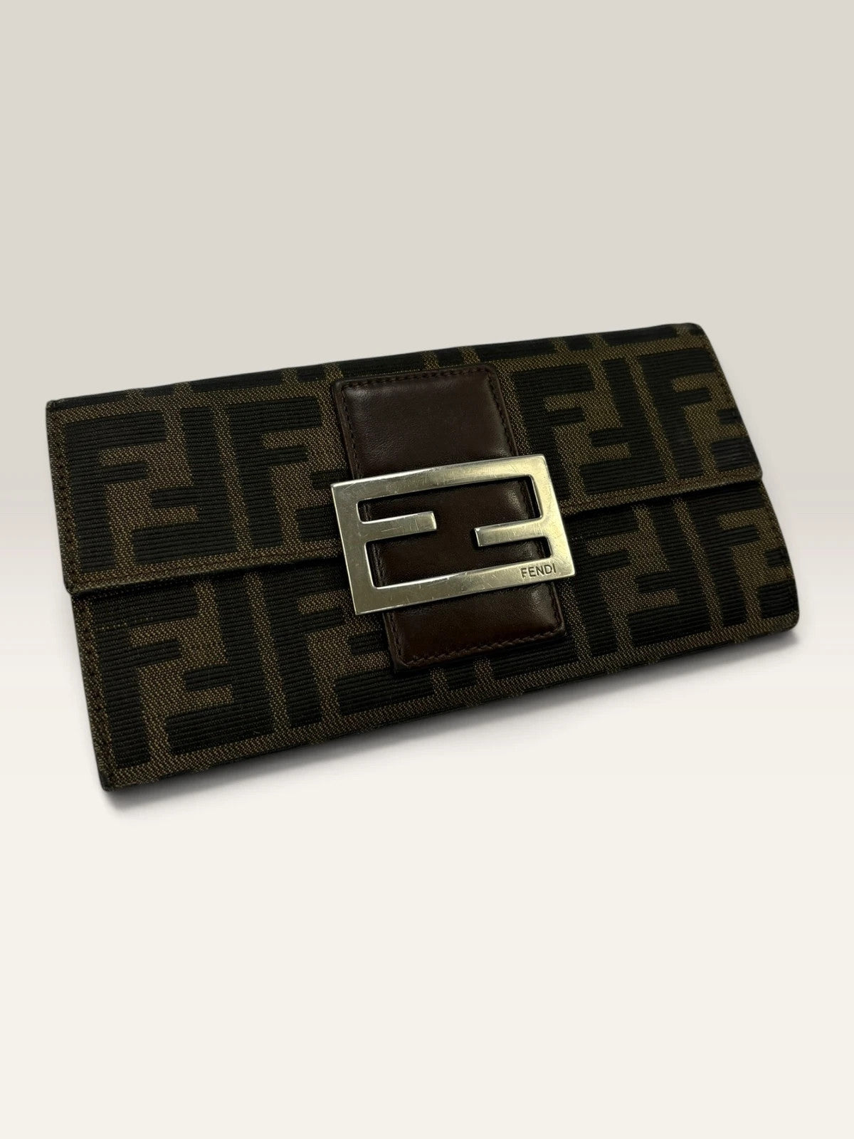 Fendi brown long wallet with Zucca FF monogram canvas and oversized logo buckle.