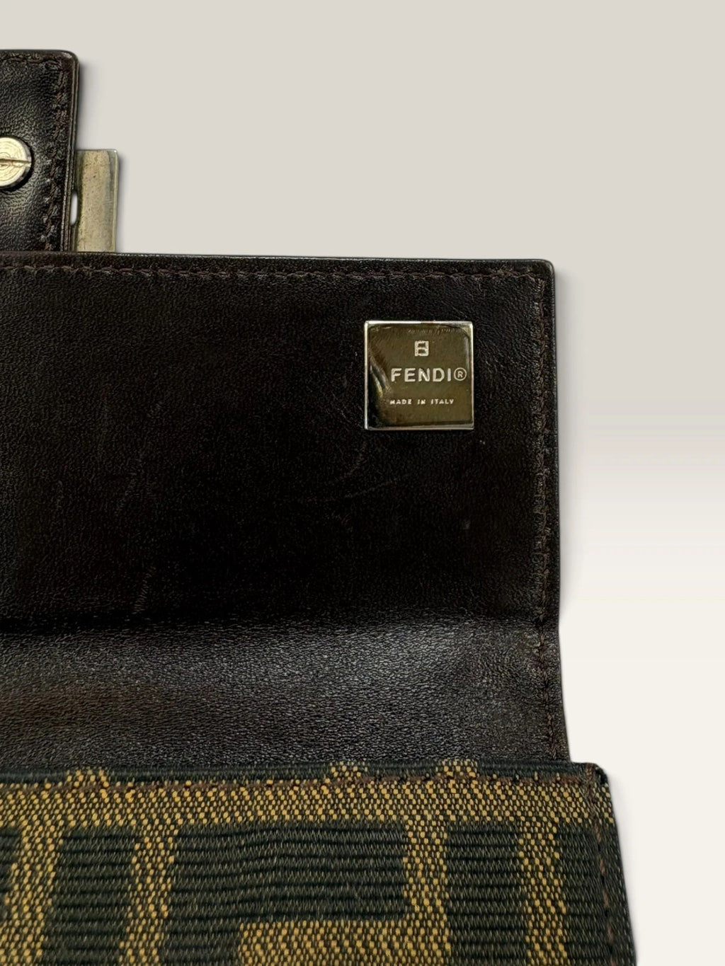 Fendi brown long wallet with Zucca FF monogram canvas and oversized logo buckle.