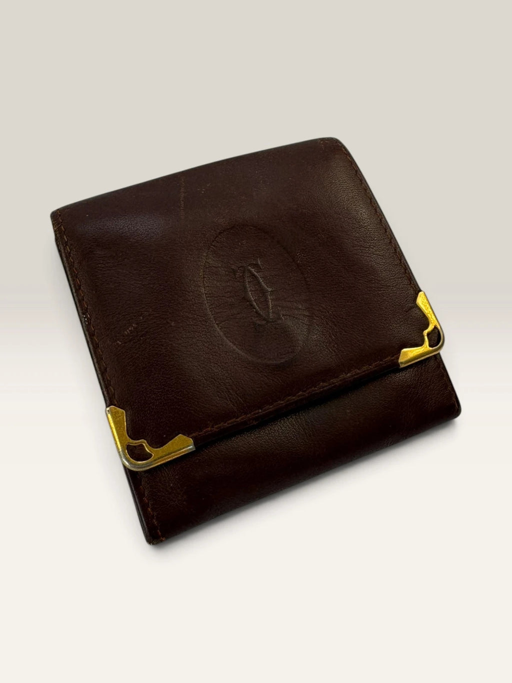 Cartier burgundy leather coin purse embossed logo with gold-tone corner hardware.