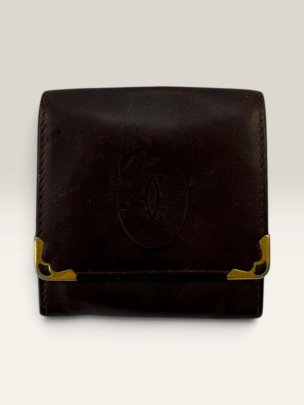 Cartier burgundy leather coin purse embossed logo with gold-tone corner hardware.