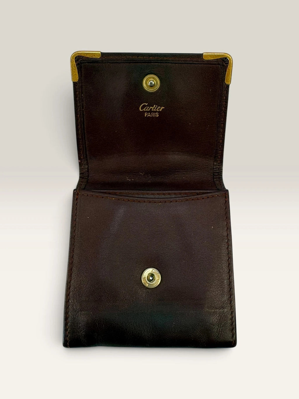 Cartier burgundy leather coin purse embossed logo with gold-tone corner hardware.