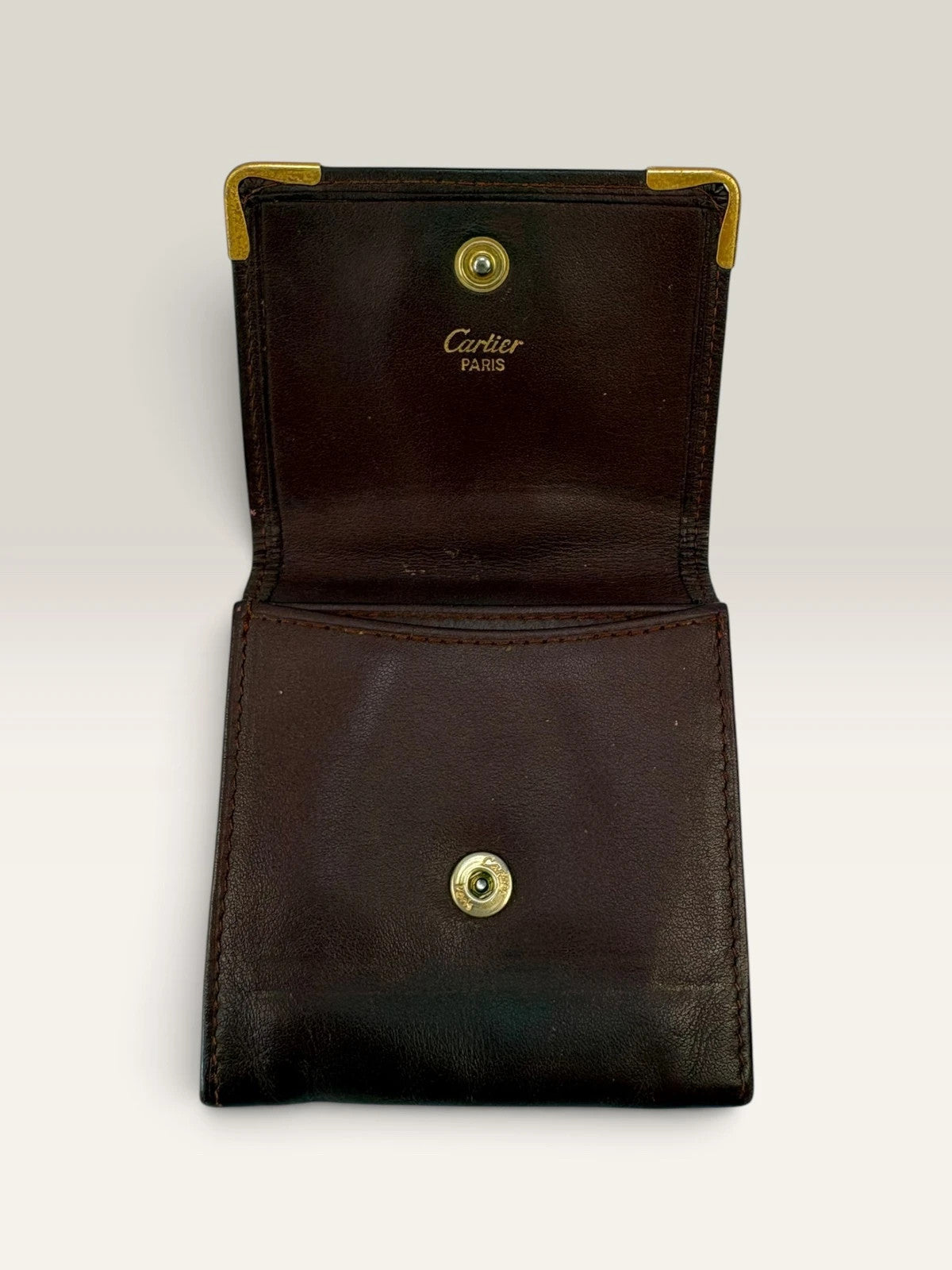 Cartier burgundy leather coin purse embossed logo with gold-tone corner hardware.