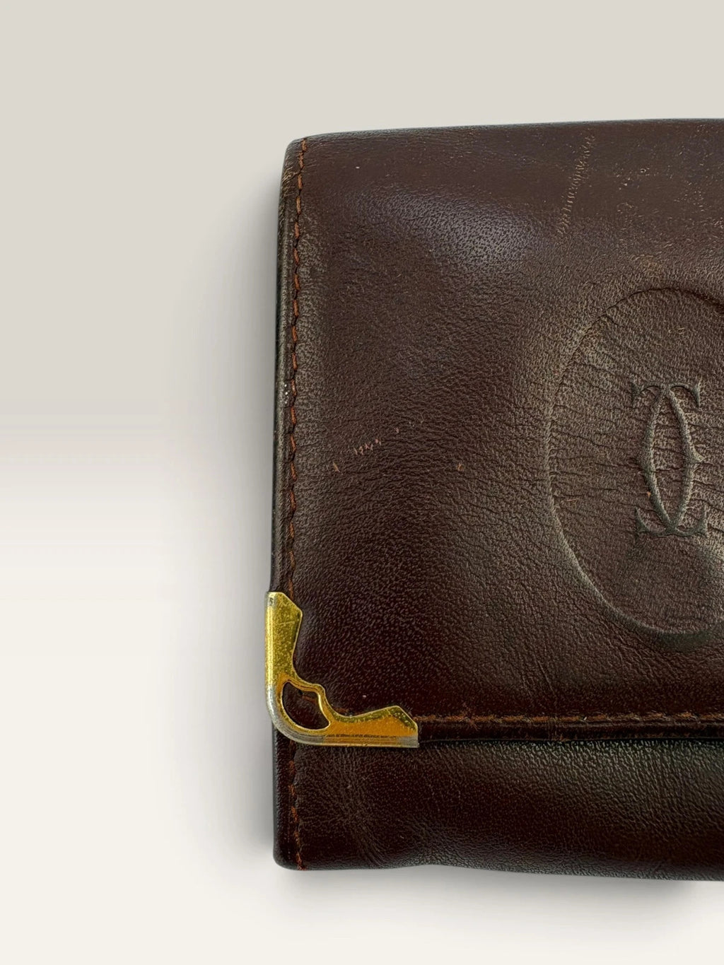 Cartier burgundy leather coin purse embossed logo with gold-tone corner hardware.