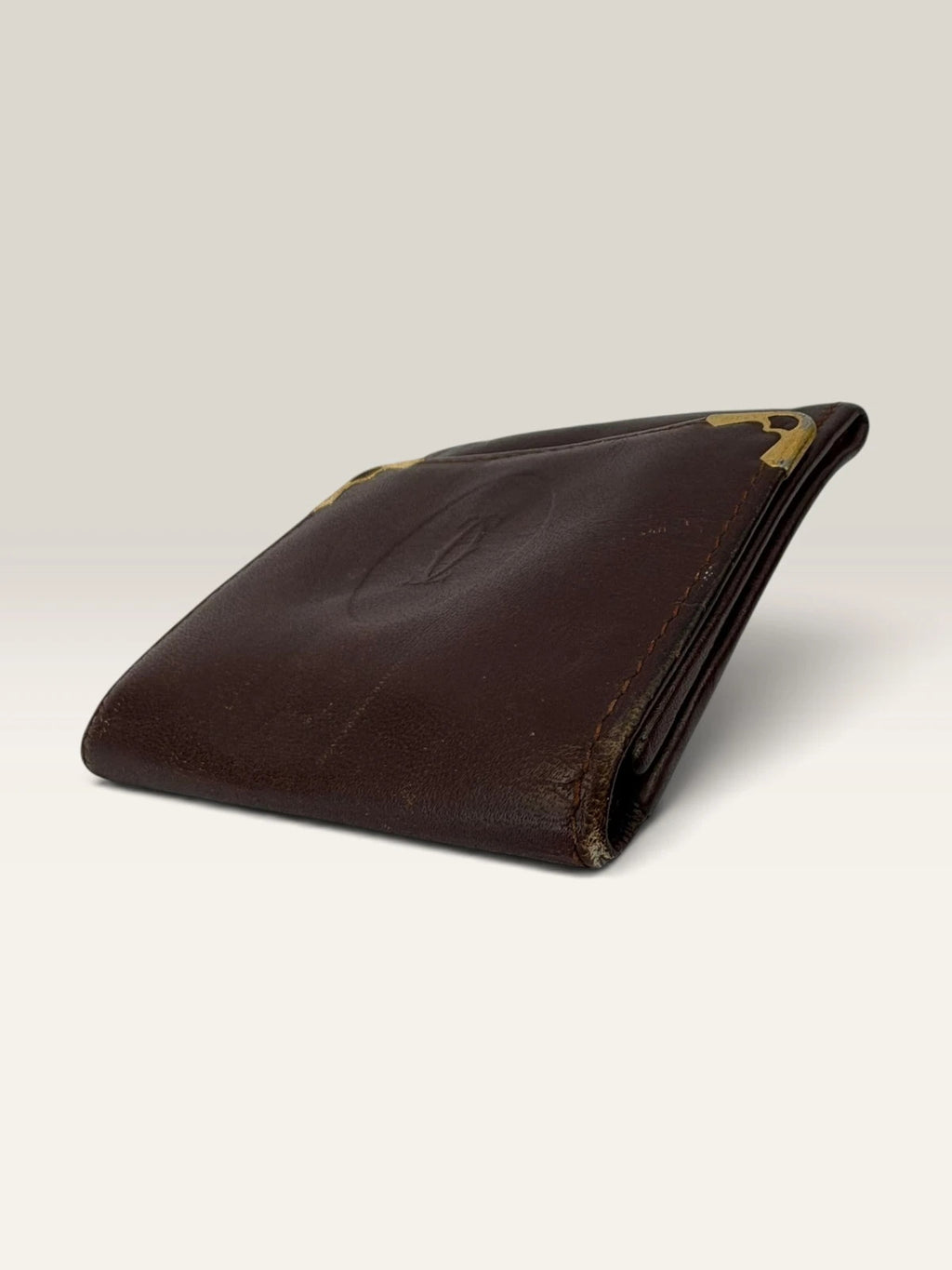 Cartier burgundy leather coin purse embossed logo with gold-tone corner hardware.