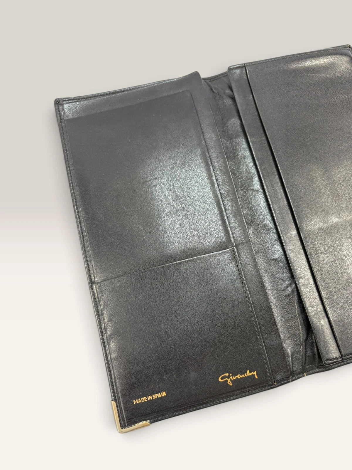 Givenchy black leather wallet embossed 4G logo, smooth texture, vintage condition.
