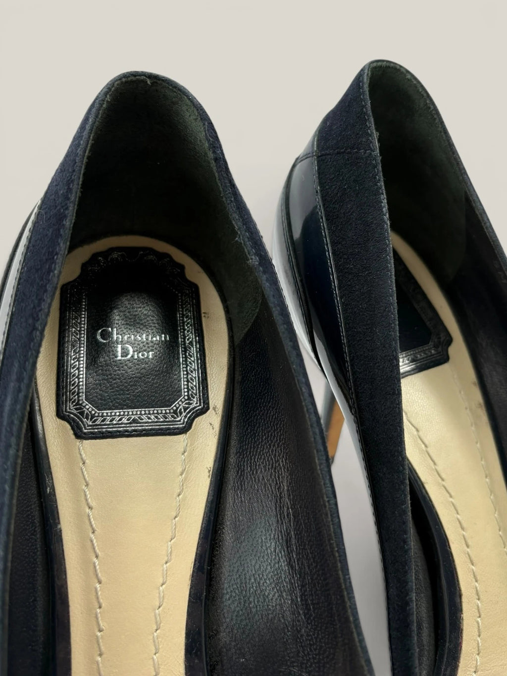 Dior navy blue stiletto heels in suede and patent leather with pointed toe design.
