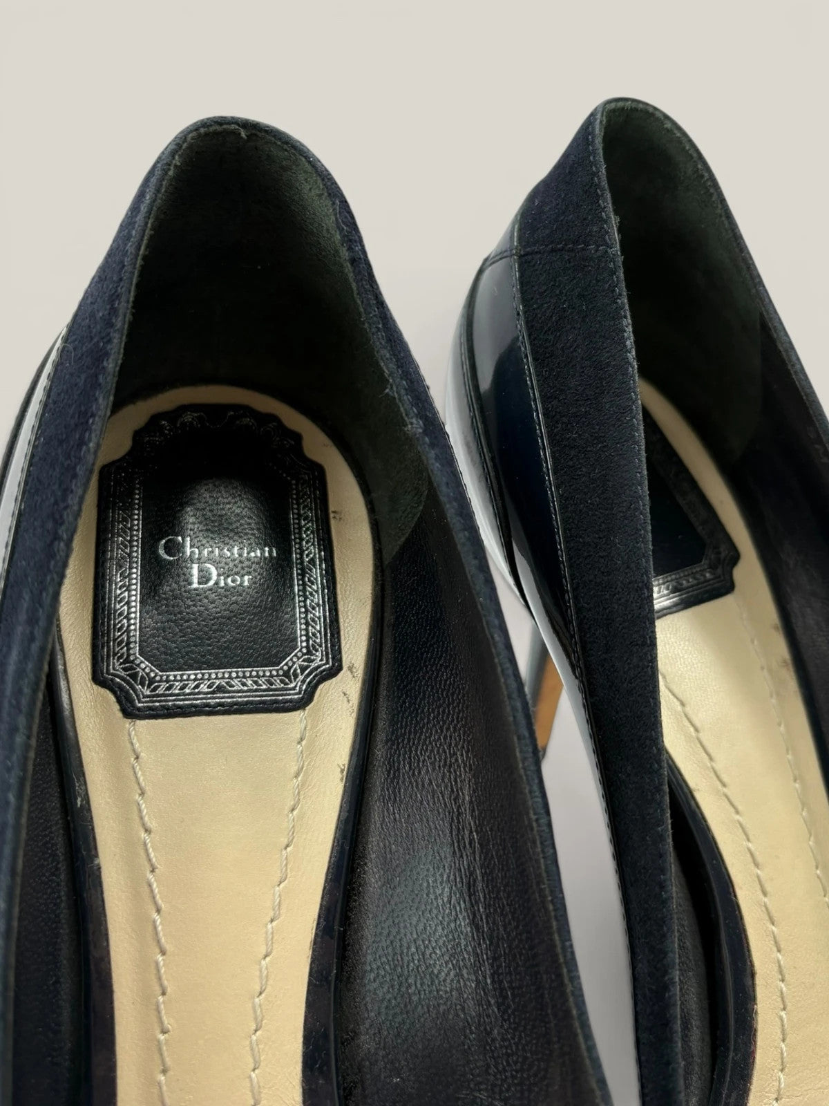 Dior navy blue stiletto heels in suede and patent leather with pointed toe design.