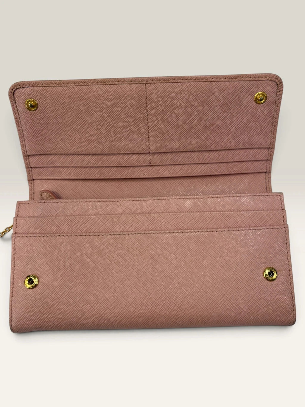 Prada pink leather wallet with structured bow detail and gold-tone hardware.