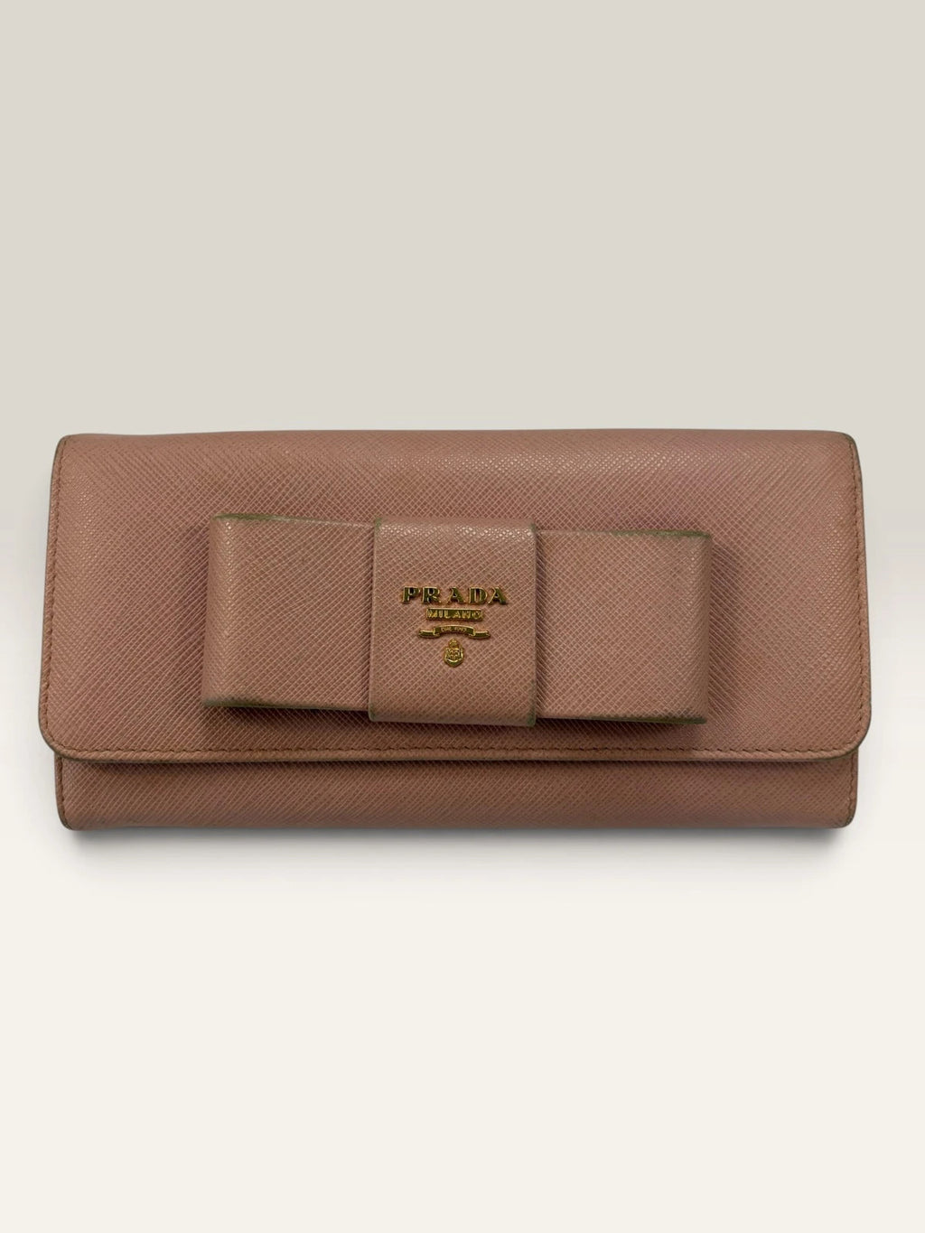 Prada pink leather wallet with structured bow detail and gold-tone hardware.