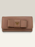 Prada pink leather wallet with structured bow detail and gold-tone hardware.