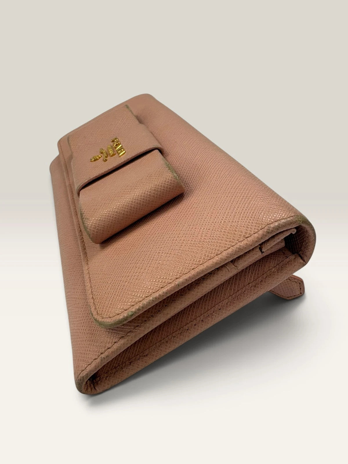 Prada pink leather wallet with structured bow detail and gold-tone hardware.