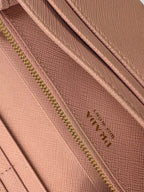 Prada pink leather wallet with structured bow detail and gold-tone hardware.