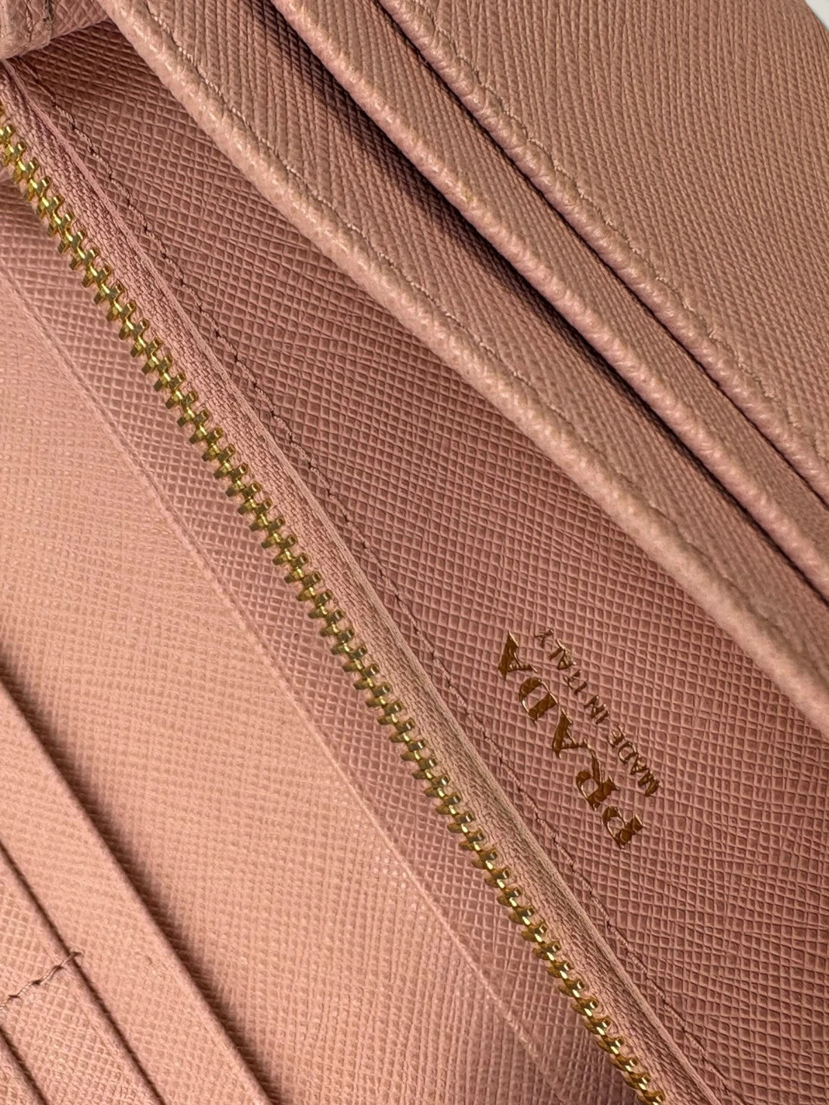 Prada pink leather wallet with structured bow detail and gold-tone hardware.