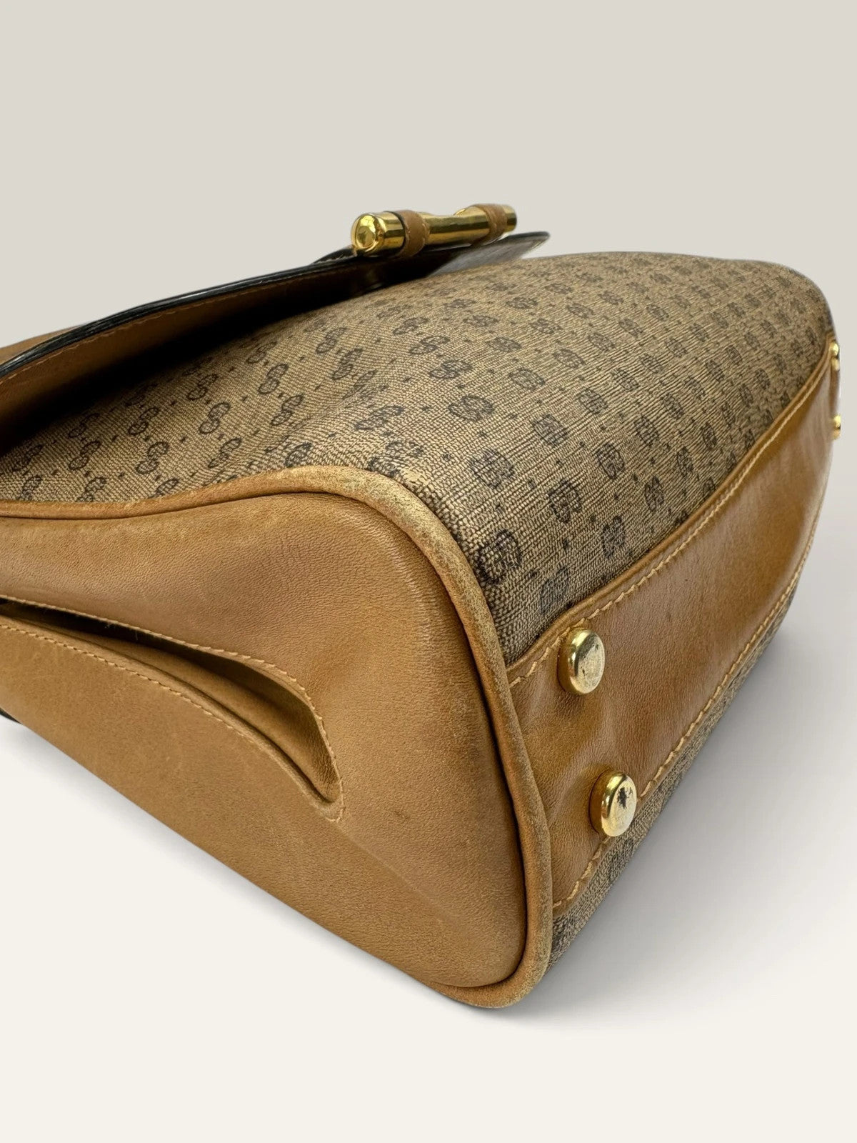Gucci beige GG monogram canvas shoulder bag with brown leather trim and gold-tone hardware.