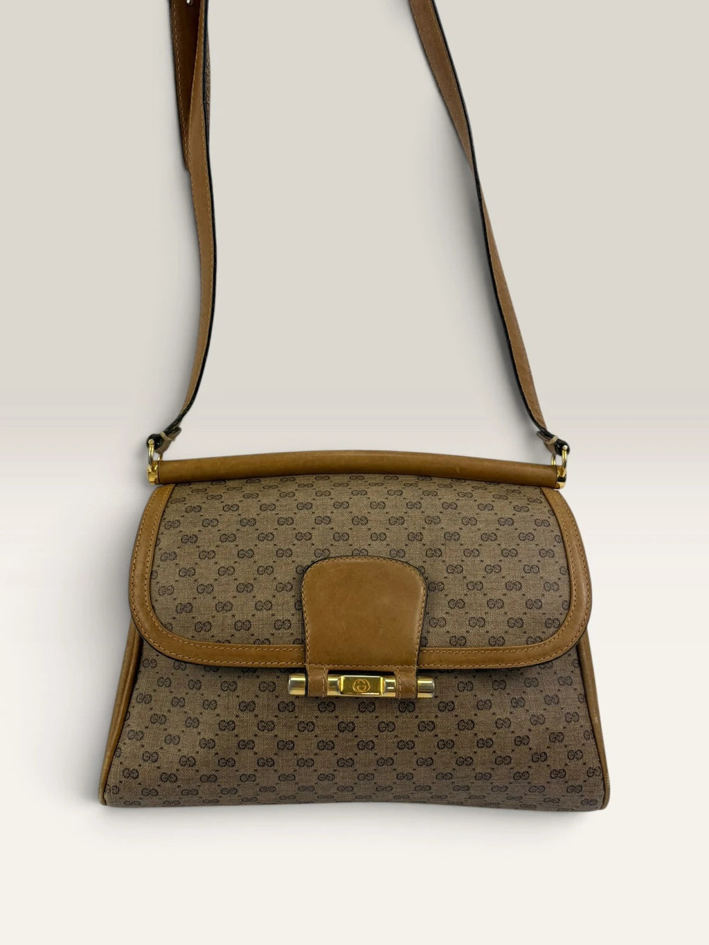 Gucci beige GG monogram canvas shoulder bag with brown leather trim and gold-tone hardware.