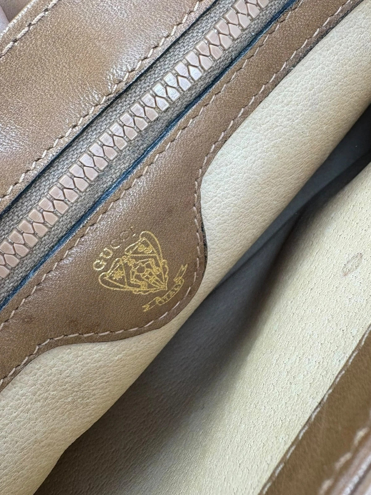 Gucci beige GG monogram canvas shoulder bag with brown leather trim and gold-tone hardware.