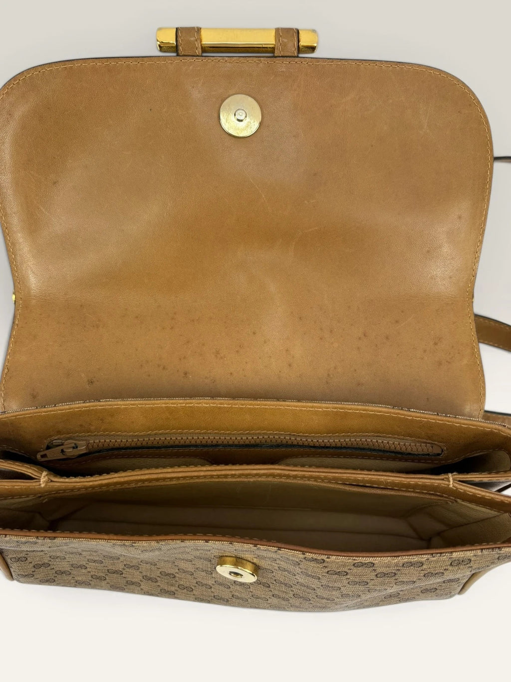 Gucci beige GG monogram canvas shoulder bag with brown leather trim and gold-tone hardware.