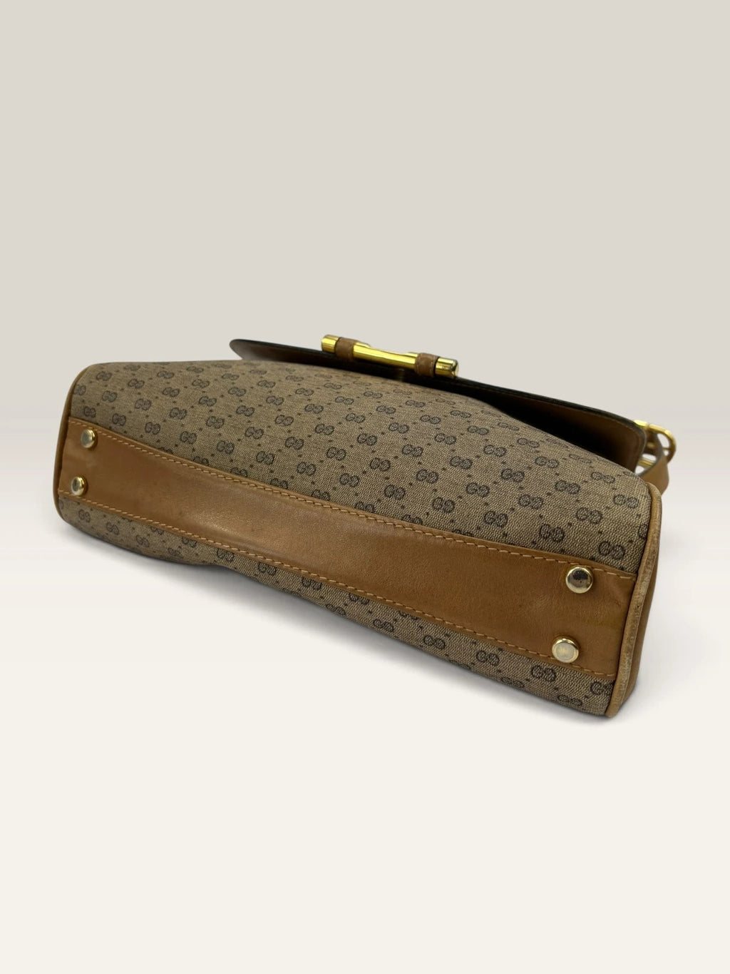 Gucci beige GG monogram canvas shoulder bag with brown leather trim and gold-tone hardware.