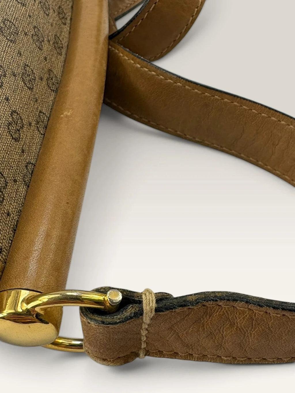 Gucci beige GG monogram canvas shoulder bag with brown leather trim and gold-tone hardware.