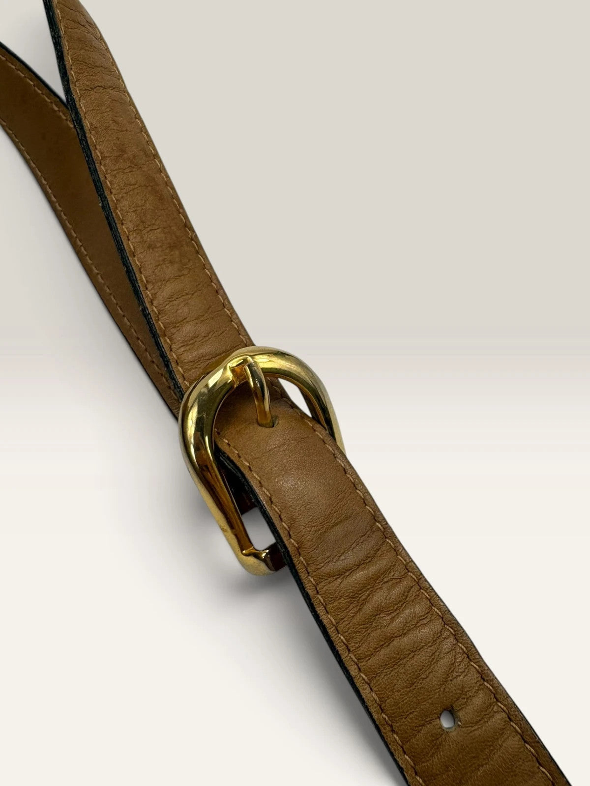 Gucci beige GG monogram canvas shoulder bag with brown leather trim and gold-tone hardware.