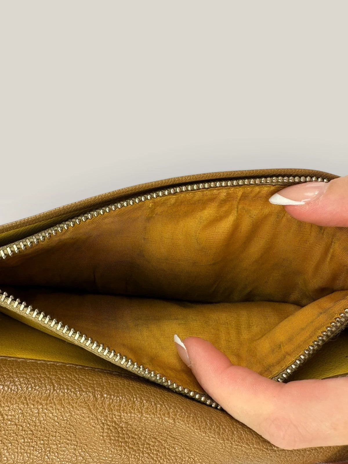 BVLGARI brown leather purse with orange accents and iconic hardware, showing vintage wear.