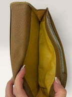 BVLGARI brown leather purse with orange accents and iconic hardware, showing vintage wear.
