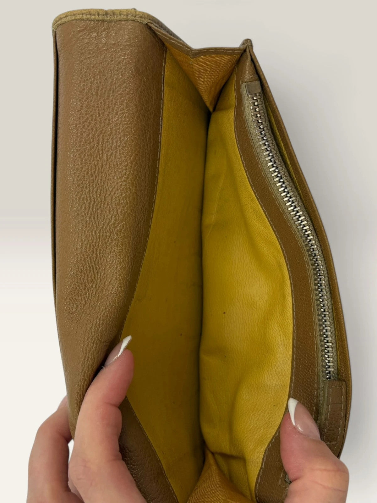 BVLGARI brown leather purse with orange accents and iconic hardware, showing vintage wear.
