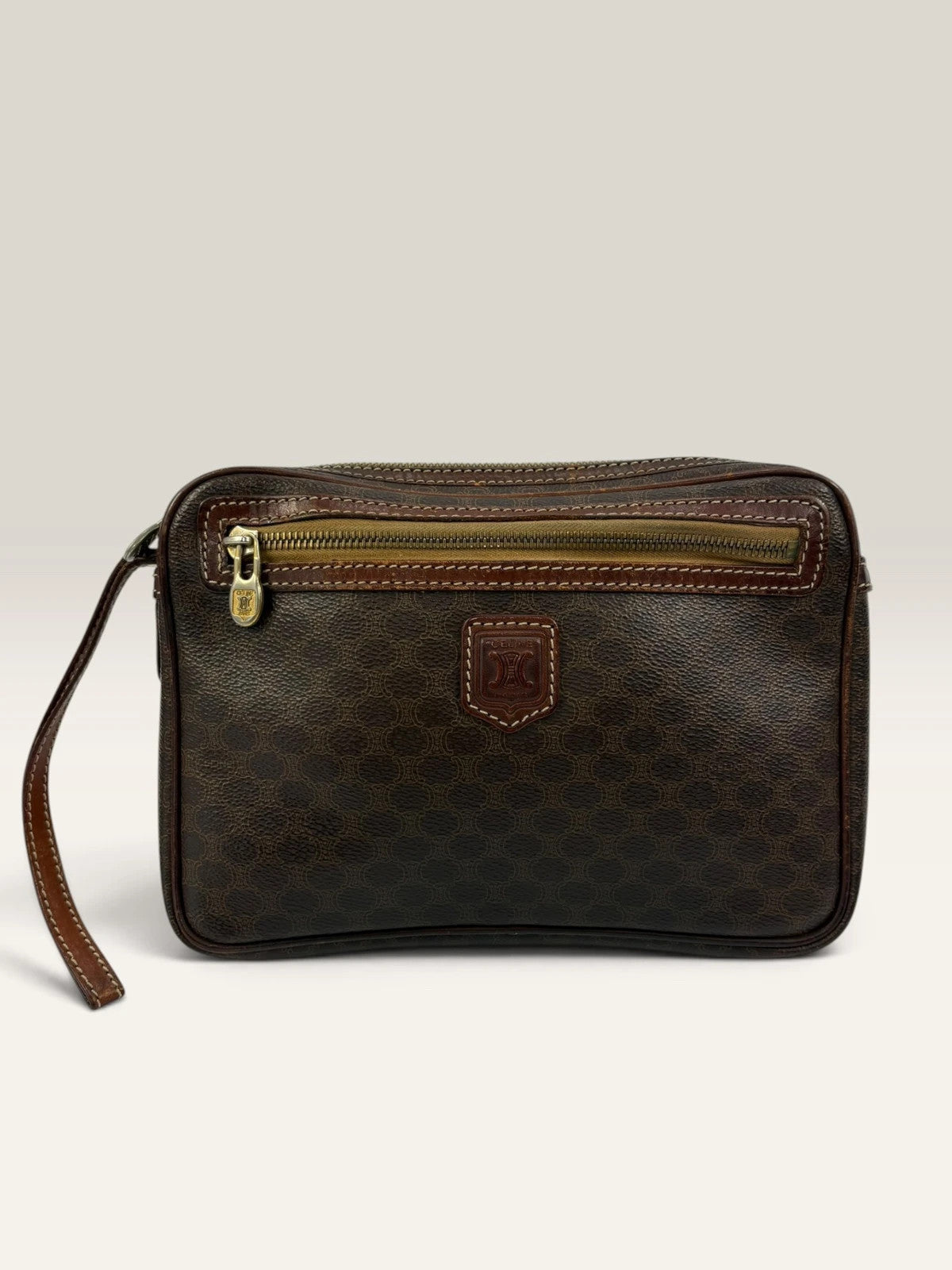 CELINE brown wristlet pouch with monogram canvas, leather trim, and gold-tone hardware.