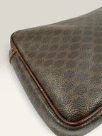 CELINE brown wristlet pouch with monogram canvas, leather trim, and gold-tone hardware.