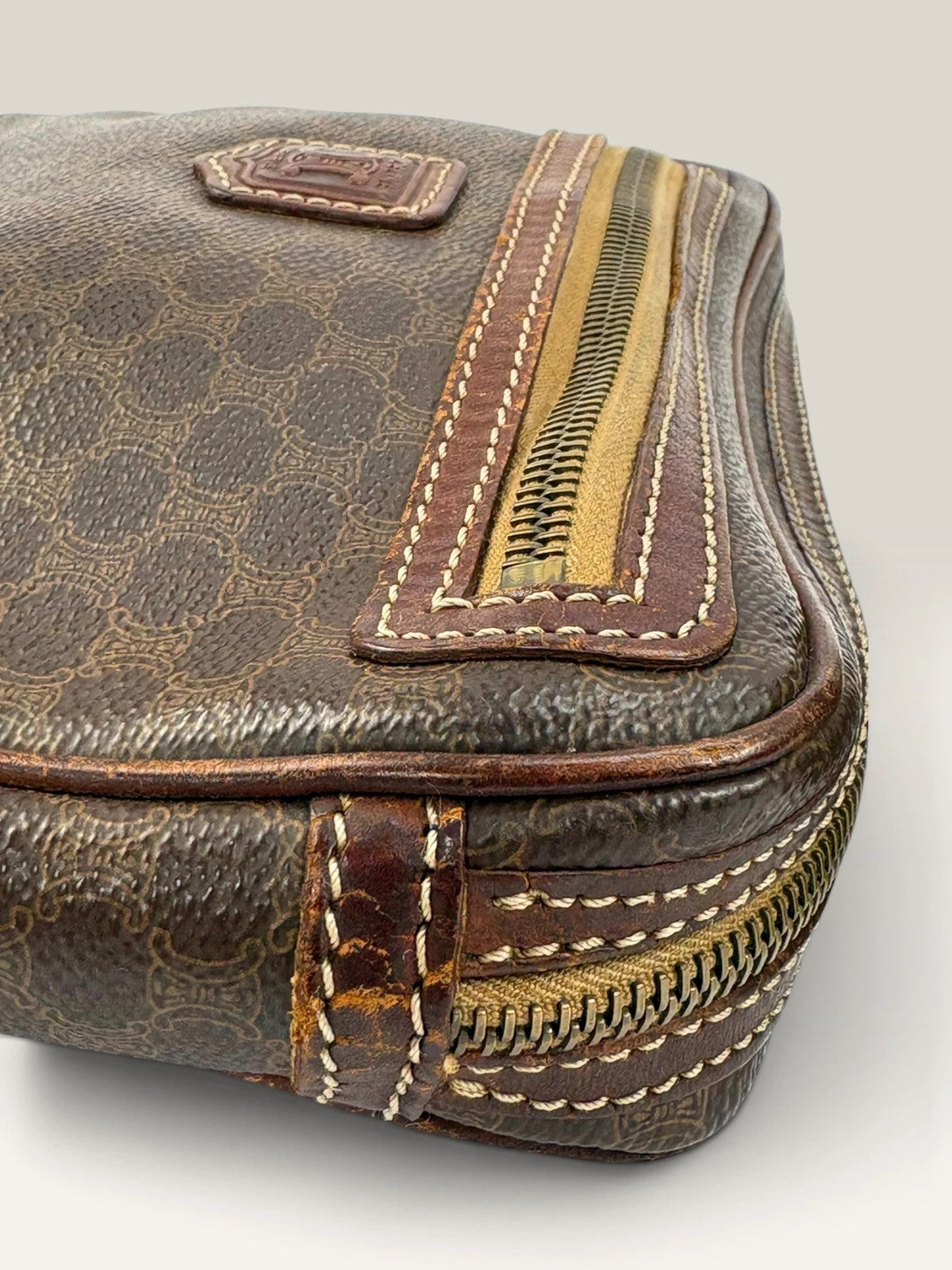 CELINE brown wristlet pouch with monogram canvas, leather trim, and gold-tone hardware.