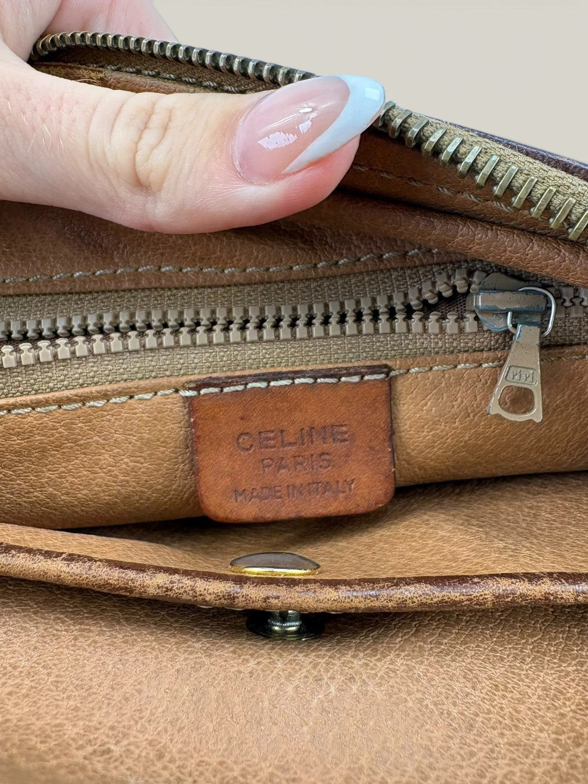 CELINE brown wristlet pouch with monogram canvas, leather trim, and gold-tone hardware.