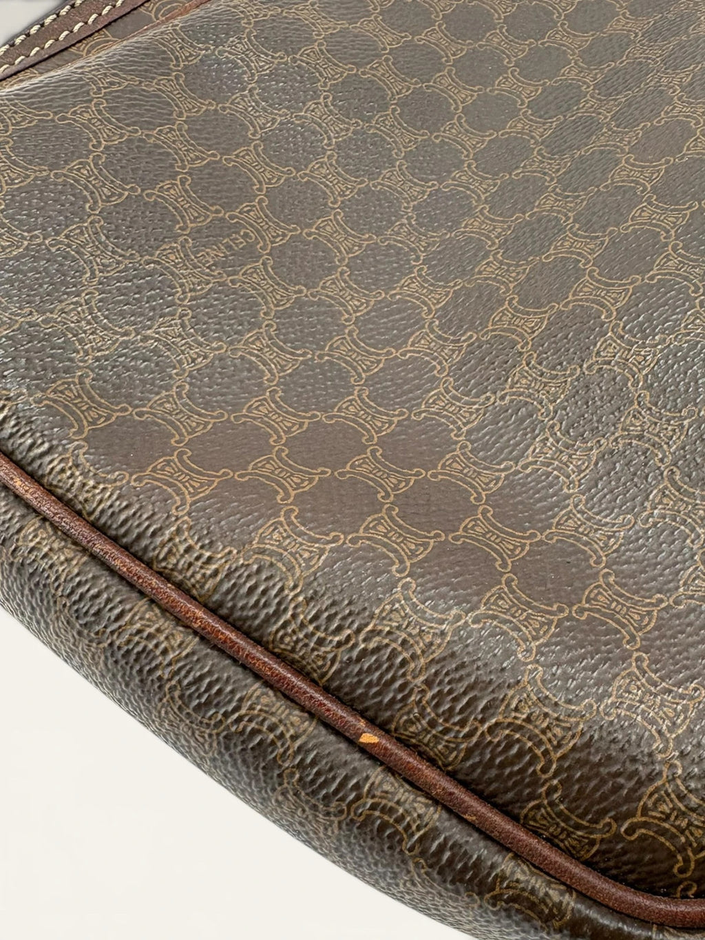 CELINE brown wristlet pouch with monogram canvas, leather trim, and gold-tone hardware.