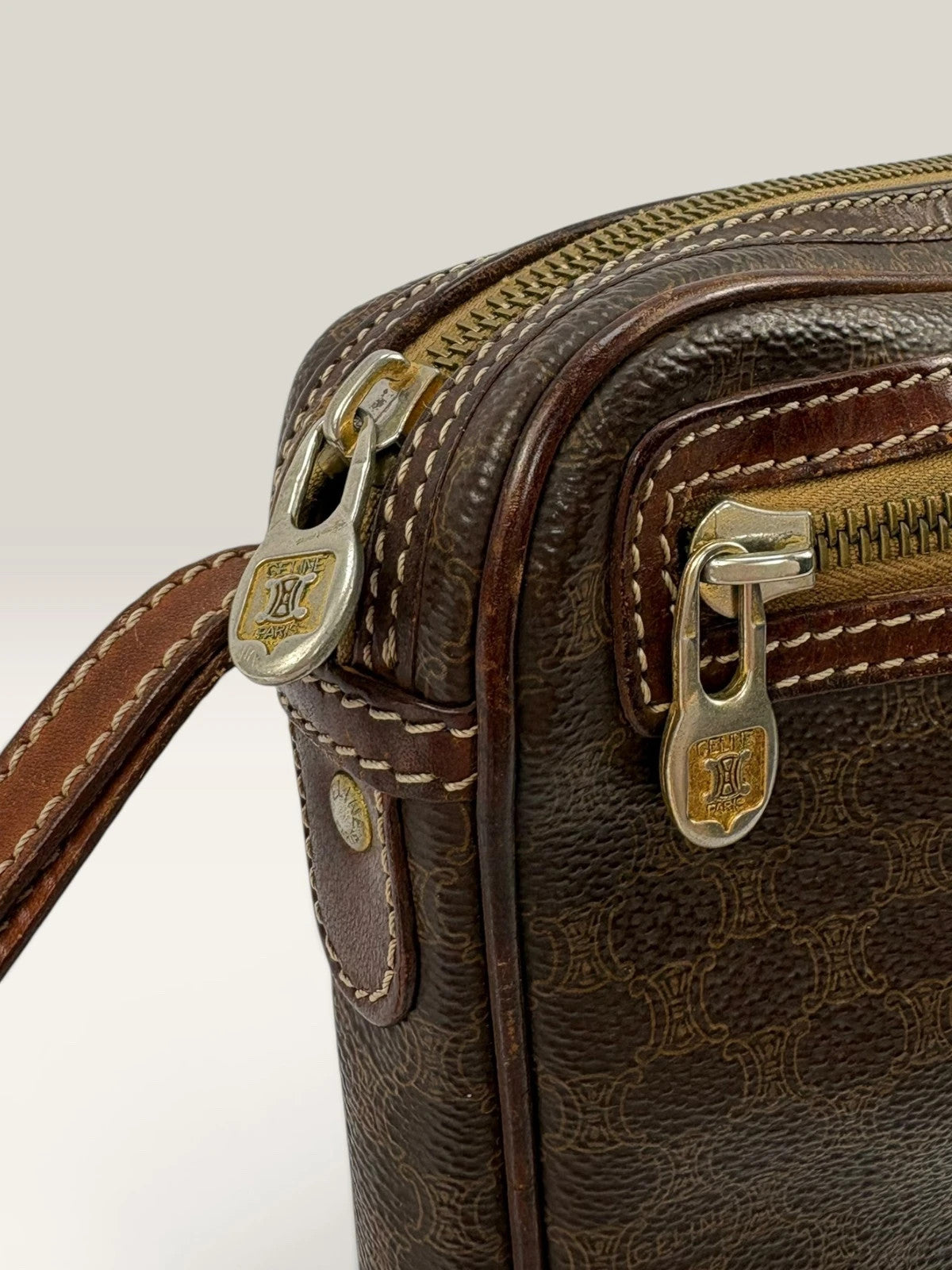 CELINE brown wristlet pouch with monogram canvas, leather trim, and gold-tone hardware.