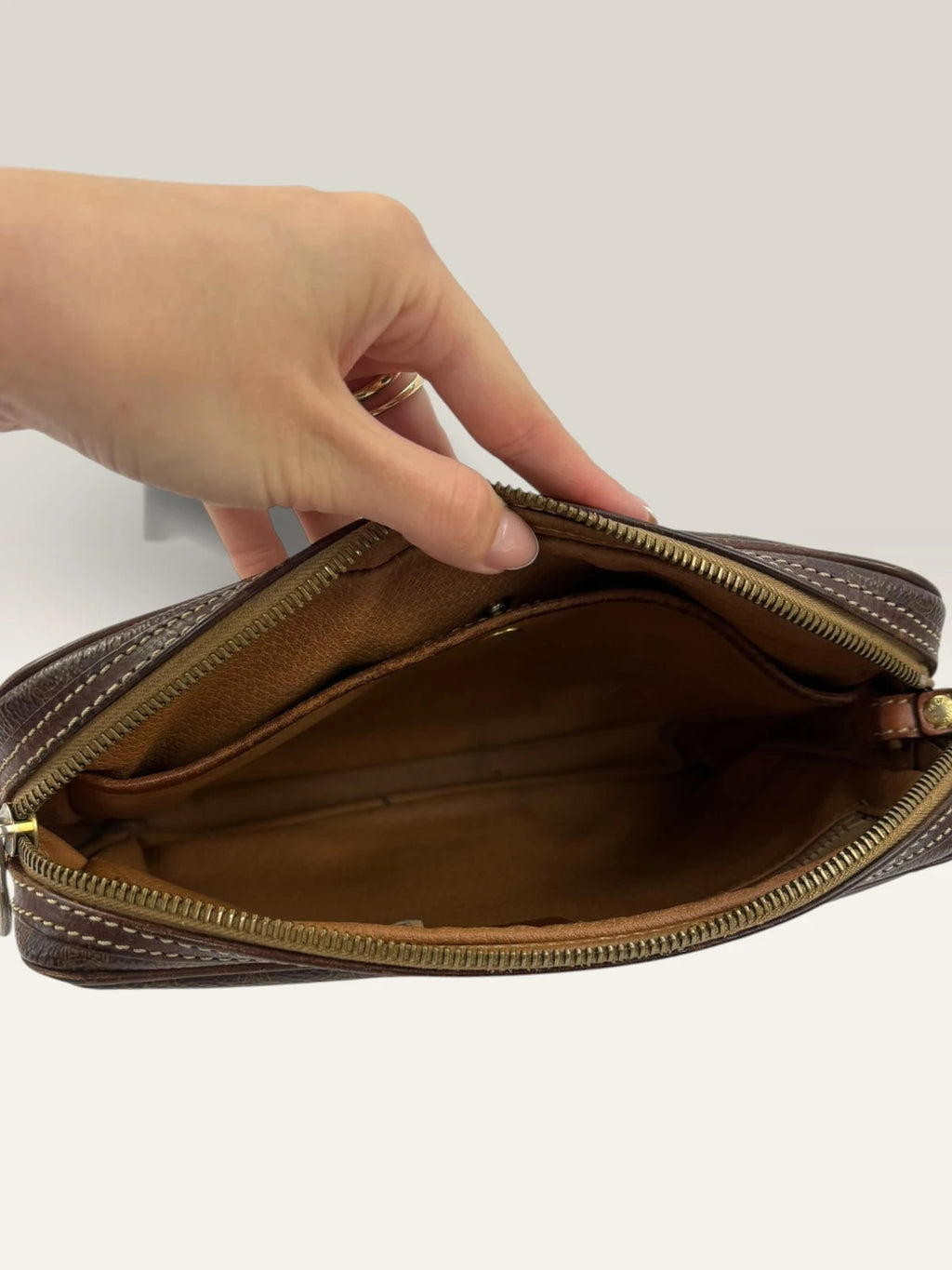 CELINE brown wristlet pouch with monogram canvas, leather trim, and gold-tone hardware.