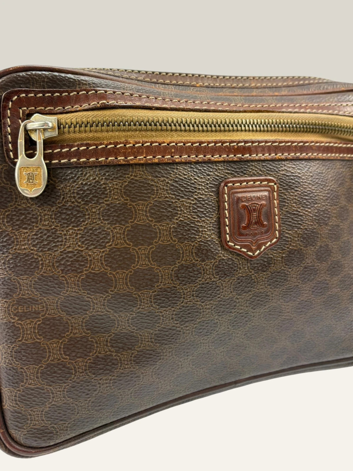 CELINE brown wristlet pouch with monogram canvas, leather trim, and gold-tone hardware.