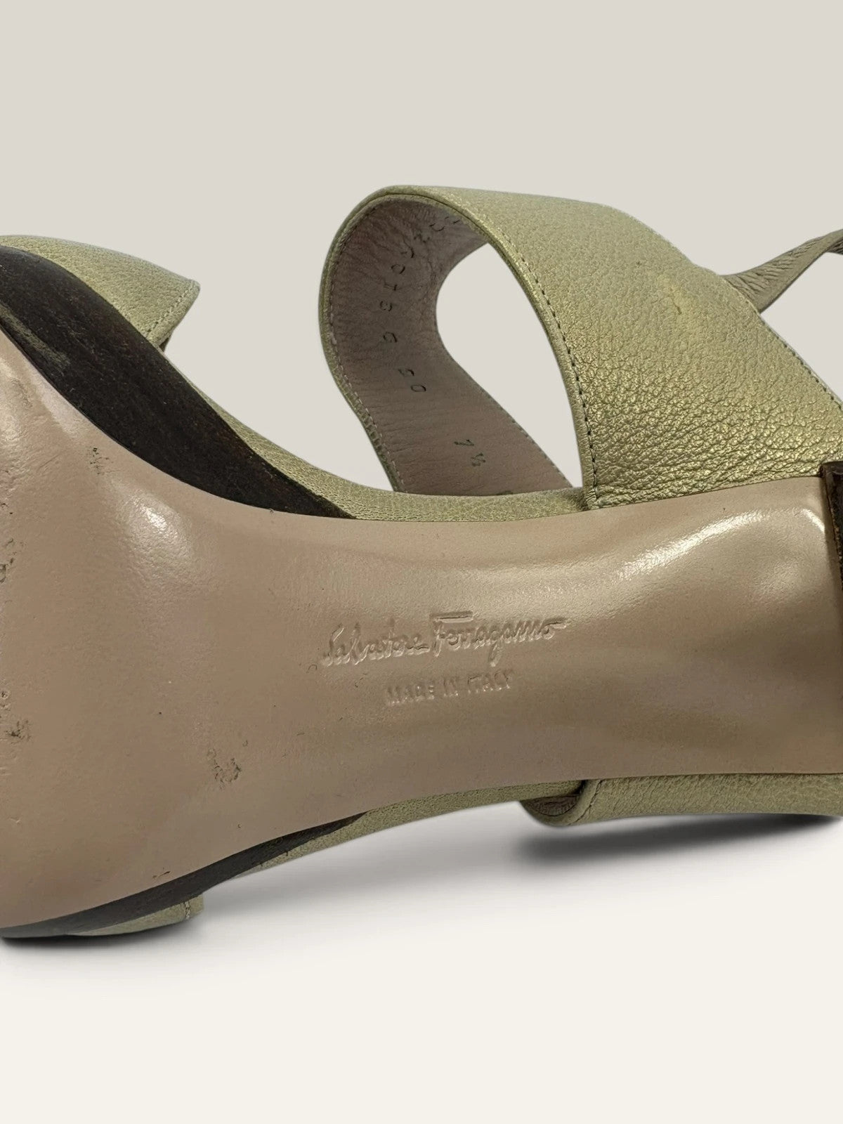 Salvatore Ferragamo beige leather slingback heels with gold accents and wooden heel.
