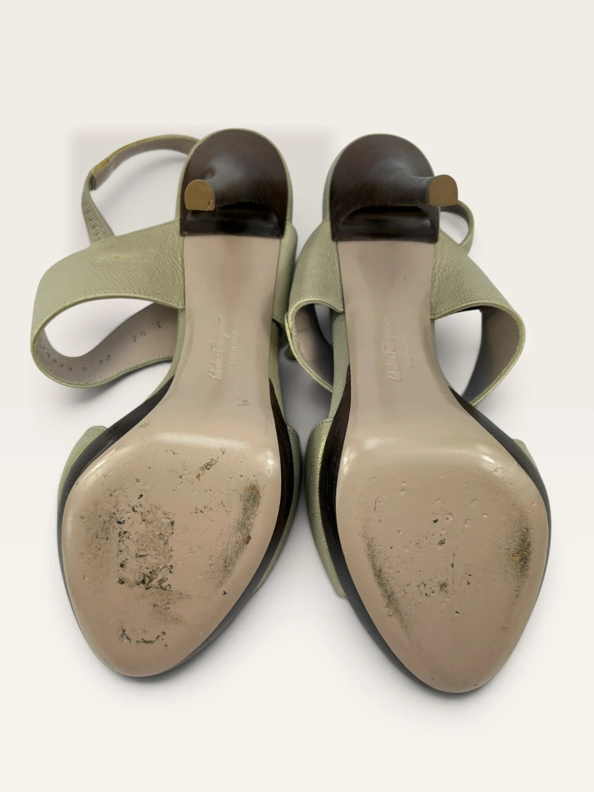 Salvatore Ferragamo beige leather slingback heels with gold accents and wooden heel.
