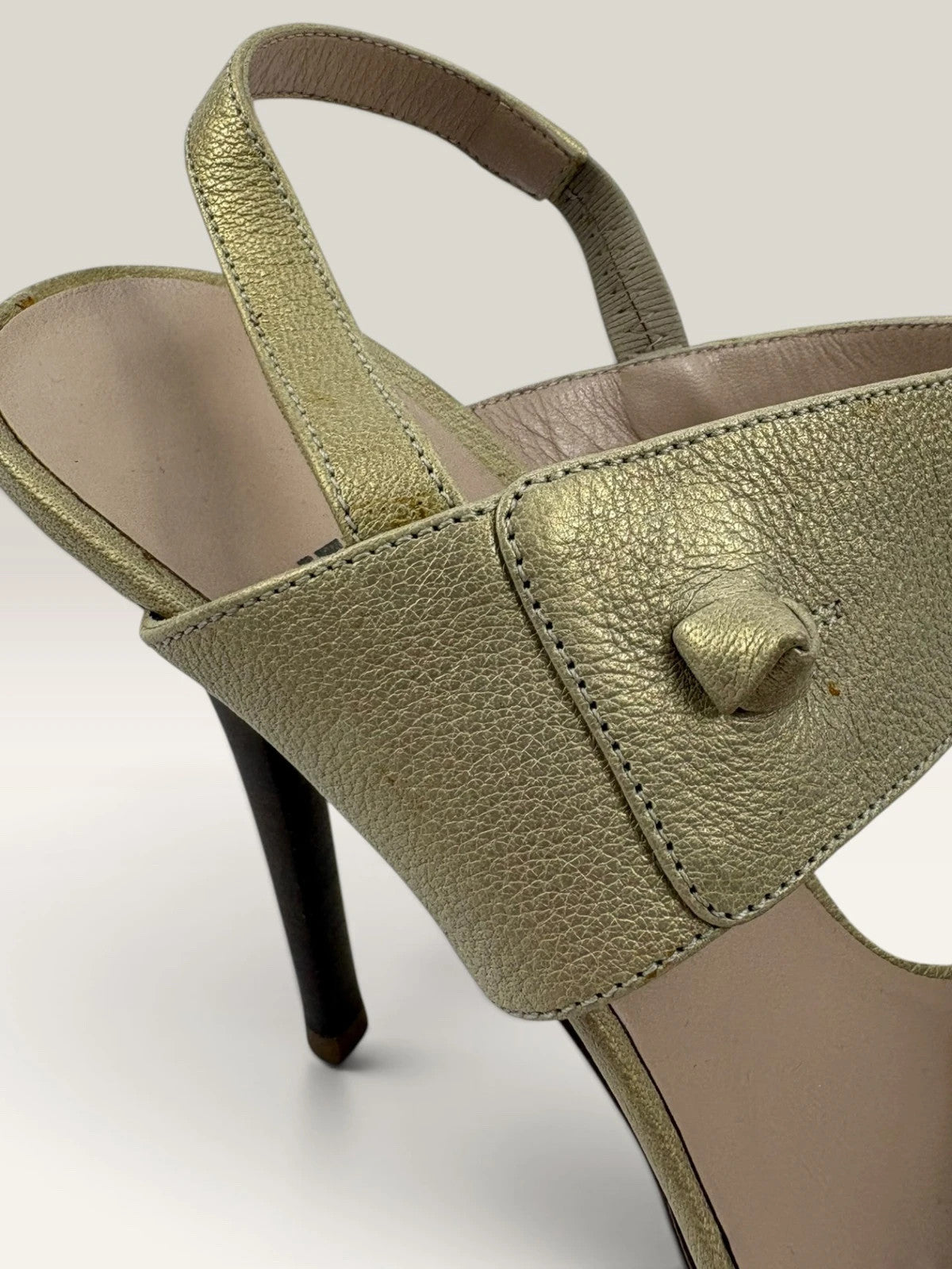Salvatore Ferragamo beige leather slingback heels with gold accents and wooden heel.