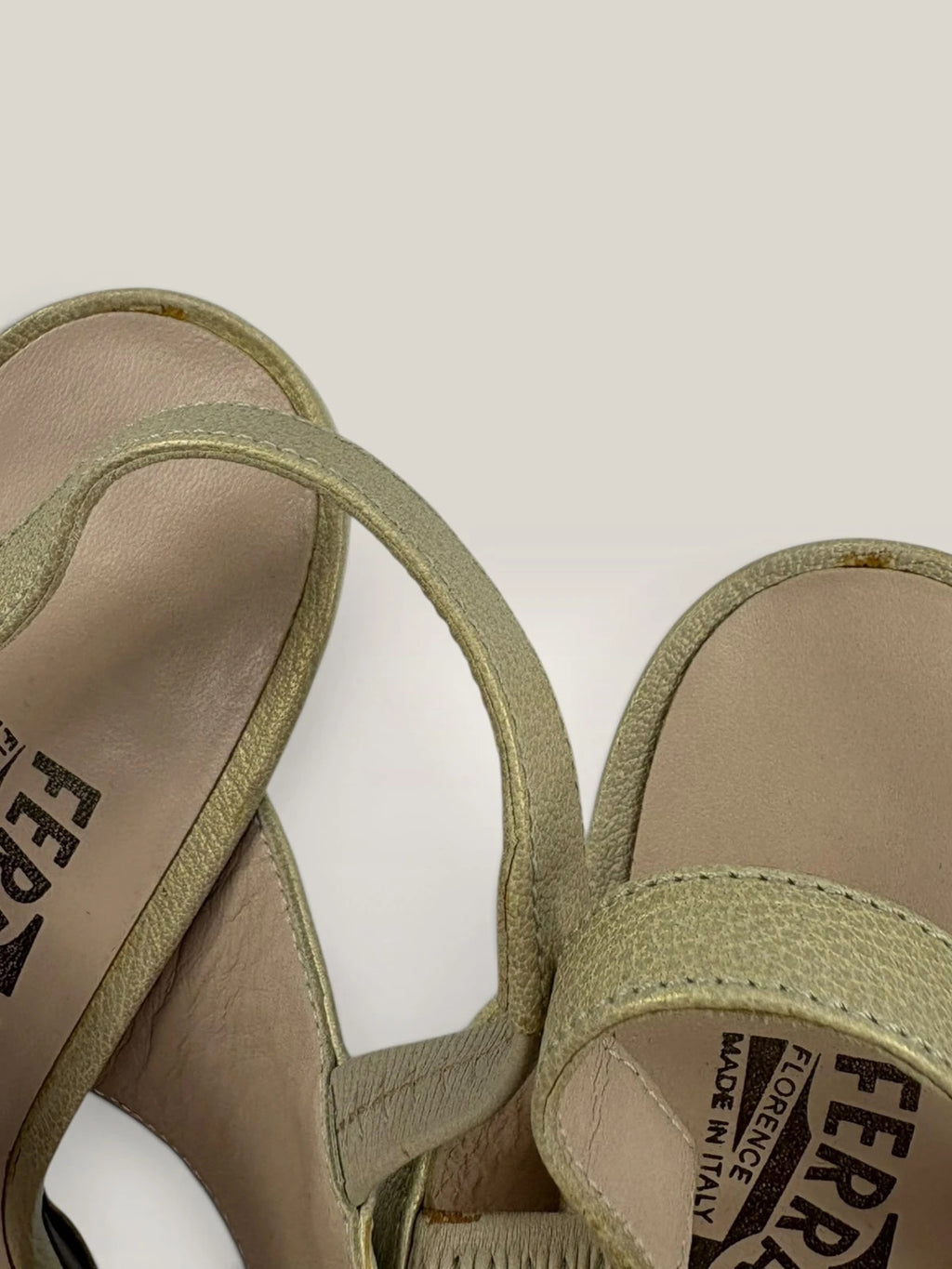 Salvatore Ferragamo beige leather slingback heels with gold accents and wooden heel.