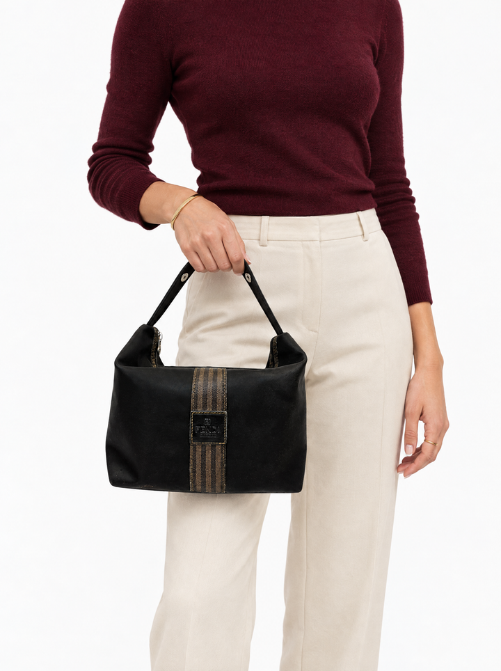 Styled photo of the vintage Fendi Pequin stripe cosmetic bag carried by a model