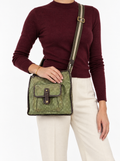 Styled photo of the vintage Louis Vuitton Mary Kate green messenger bag worn crossbody by a model