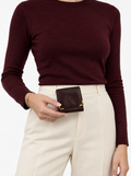 Styled photo of the vintage Must de Cartier burgundy coin purse held by a model