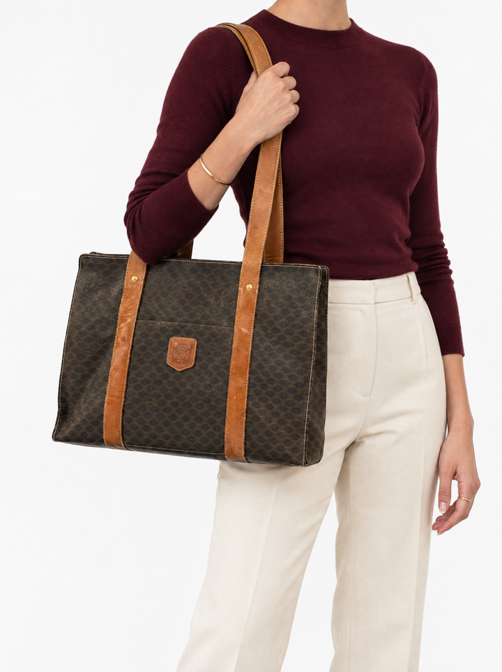 Styled photo of the vintage Celine Macadam tote carried on the shoulder by a model