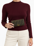 Styled photo of the vintage Fendi Zucca long wallet held by a model