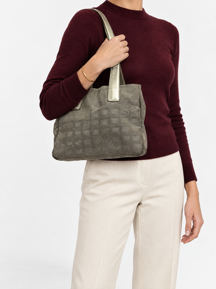 Styled photo of the Chanel New Travel Line small tote carried on the shoulder by a model