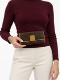 Styled photo of the vintage Celine Macadam long wallet held by a model